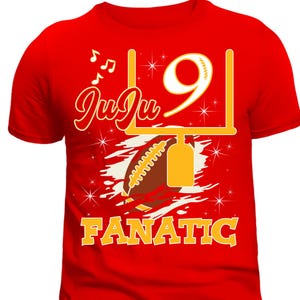 May include: Red t-shirt featuring a yellow and brown football graphic, a football goalpost, and the text "JuJu 9 Fanatic".