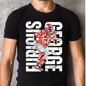 May include: Black t-shirt featuring a white graphic of a football player running with the text "George" and "Furious" on either side of the player.