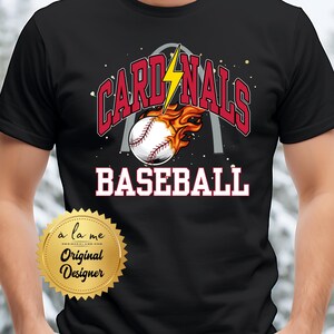 May include: Black t-shirt with a red and white baseball graphic and the text "Cardinals Baseball" with a lightning bolt and an archway in the background.