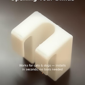 Puede incluir: Un cierre de persiana de plástico blanco impreso en 3D con un recorte en forma de U. El texto en la imagen dice: HANDMADE 3D PRINTED, Stop Pets From Opening Your Blinds, Works for cats & dogs — installs in seconds, no tools needed, 3DPenguinShop.