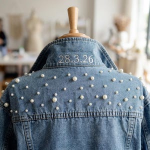 Puede incluir: Una taza de cerámica blanca con un asa negra y el texto "But First, Coffee" en negro, con una fuente de estilo manuscrito. La taza está sobre una superficie blanca.