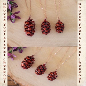 May include: A set of five pine cone necklaces with varying sizes. The necklaces are made of copper and feature a red-brown pine cone pendant. The pine cones are detailed and realistic.
