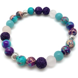 May include: A bracelet made with purple, blue, and turquoise gemstone beads, lava rock beads, and silver spacers.