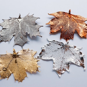 May include: Four metal maple leaf charms in silver, gold, and copper.