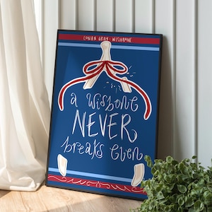 Puede incluir: Una impresión artística enmarcada con un fondo azul presenta un diseño de espina de pescado y el texto "A wishbone NEVER breaks even". La impresión incluye detalles en rojo y blanco y el texto "CONAN GRAY - WISHBONE" en la parte superior. La obra de arte está en un marco negro.