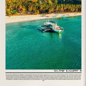 May include: A scenic aerial view of a white boat with a black and silver frame floating on turquoise water near a white sand beach. Lush green trees line the shore. The image includes the coordinates 121.7740&deg; E | 12.8797&deg; N.