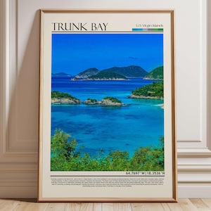 Op de afbeelding: Een ingelijste print met Trunk Bay op de Amerikaanse Maagdeneilanden. De afbeelding toont een turquoise zee, groene eilanden en de tekst "TRUNK BAY". De print zit in een houten lijst, ideaal voor wanddecoratie.
