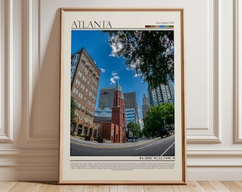 May include: Framed print of Atlanta, Georgia, with a fisheye perspective. The image shows a red brick church, skyscrapers, and a blue sky. The city's name is at the top. Coordinates are displayed at the bottom of the print.