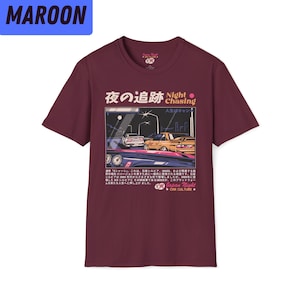 May include: Maroon t-shirt with a graphic print of two cars driving at night. The text "Night Chasing" is printed in white with a red circle. The Japanese text "夜の追跡" is printed in white with a pink circle. The text "人生はチャンス" is printed in white. The text "Japan Night Car Culture" is printed in white.