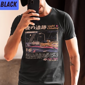 May include: Black t-shirt with a graphic print of two cars driving at night. The text on the shirt reads "Night Chasing" and "Japan Night Car Culture".