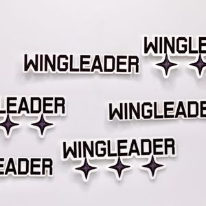 May include: Six black and white stickers with the text "WINGLEADER" and three black stars.