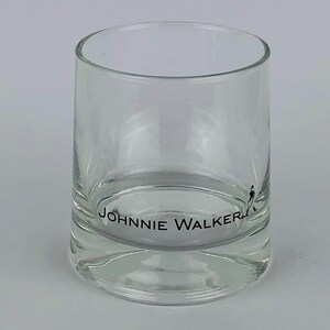 May include: A clear glass tumbler with the words "JOHNNIE WALKER" printed on the bottom.
