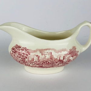 Pode incluir: Um molho de cerâmica branca com um design de castelo rosa e branco.