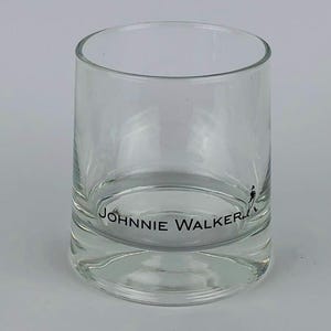 May include: A clear glass tumbler with the words "JOHNNIE WALKER" printed on the bottom.