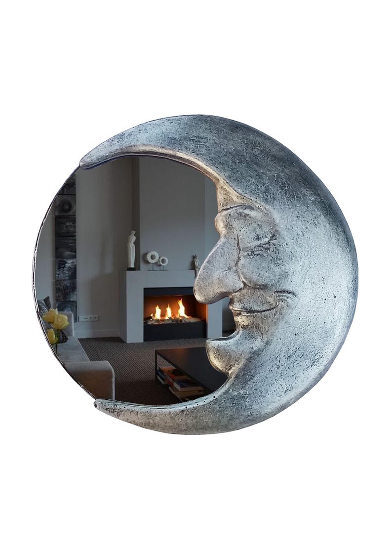 May include: A silver-colored crescent moon mirror with a textured surface. The mirror's reflective surface shows a room with a fireplace and furniture. The moon has a smiling face design.