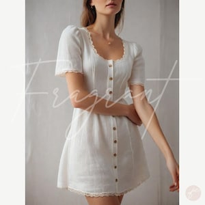 May include: A white button-up dress with a lace trim and short sleeves. The dress has a fitted bodice and a flowy skirt.