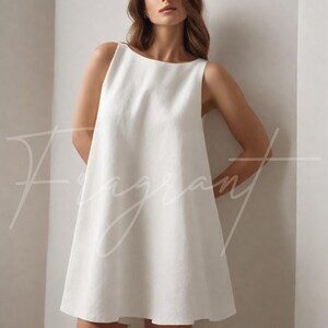 May include: A sleeveless, white linen dress with a boat neckline. The dress has a simple, A-line silhouette and falls to mid-thigh. The word "Fragrant" is written in cursive across the front of the dress.