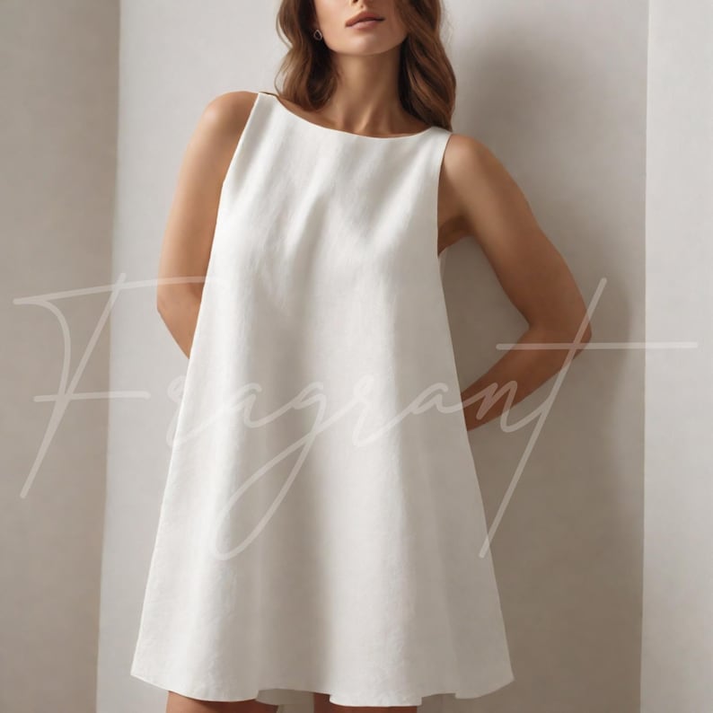 May include: A sleeveless, white linen dress with a boat neckline. The dress has a simple, A-line silhouette and falls to mid-thigh. The word "Fragrant" is written in cursive across the front of the dress.