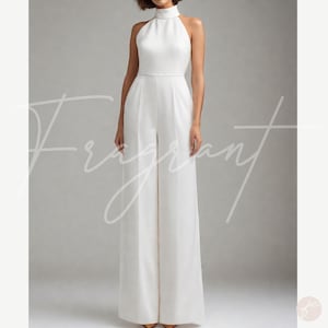 May include: A white halter jumpsuit with a high neck and wide legs. The jumpsuit is made of a smooth, silky fabric.