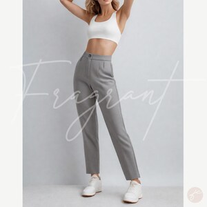 Puede incluir: Pantal&oacute;n gris de cintura alta con corte recto. El pantal&oacute;n tiene cierre de bot&oacute;n y cremallera y est&aacute; hecho de una tela lisa y antiarrugas.
