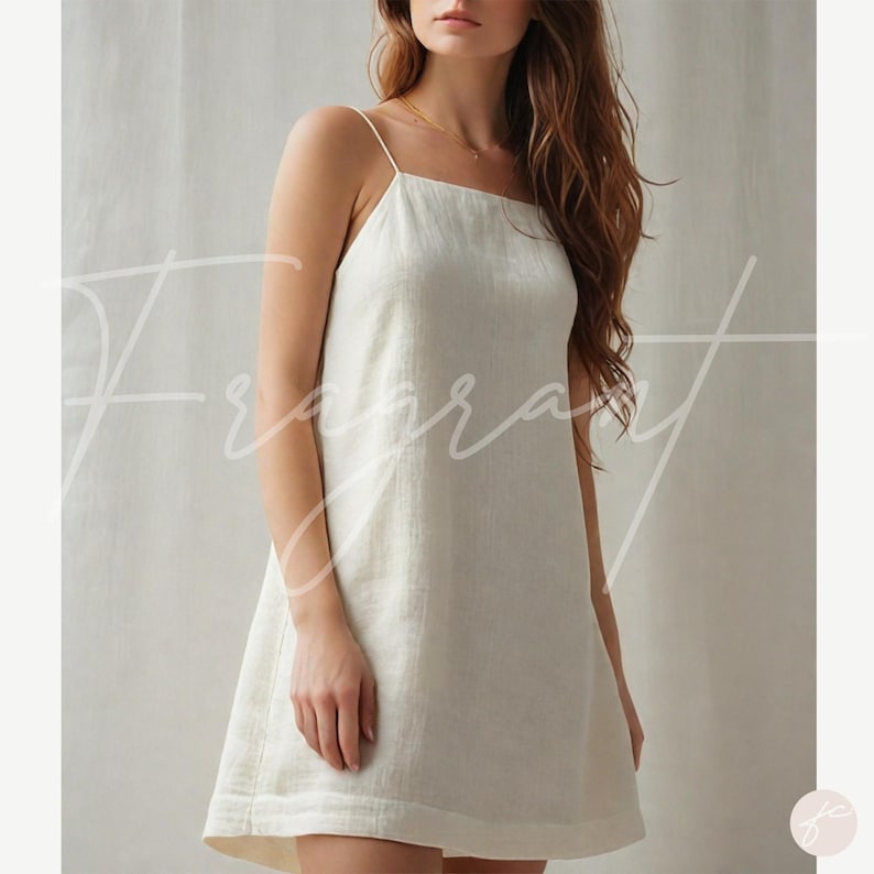 May include: A white linen slip dress with thin straps. The dress has a square neckline and a slightly A-line silhouette.