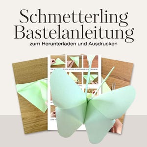 Op de afbeelding: Een lichtgroene papieren vlinder met gedetailleerde vleugels is het middelpunt van deze afbeelding. De vlinder is geplaatst voor een gedrukte instructievel en een houten oppervlak. De tekst bovenaan luidt "Schmetterling Bastelanleitung zum Herunterladen und Ausdrucken."