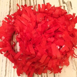 May include: A large bunch of red, shiny, crinkled tissue paper streamers.