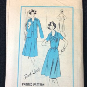 May include: A vintage sewing pattern for a dress, featuring two models wearing blue dresses. The pattern is titled "First Lady" and is a "Prominent Designer" pattern. The pattern number is A577 and the size is 8.