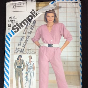 May include: A sewing pattern for a jumpsuit with a V-neck and long sleeves. The pattern is available in sizes 8-10-12, 10-12-14, and 12-14-16. The pattern is from Simplicity and designed by Cathy Hardwick.