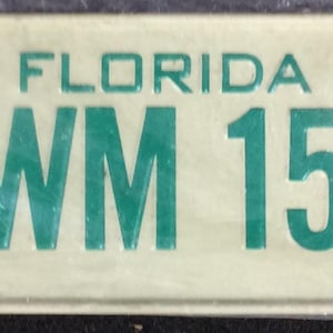 Puede incluir: Una placa de matrícula blanca de Florida con texto verde. La placa dice "FLORIDA" y "RWM 155" y tiene el año "78" en la esquina superior derecha.