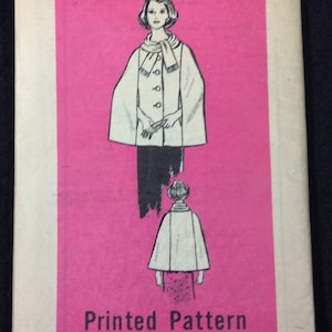 Puede incluir: Un patrón de costura vintage para una capa con fondo rosa. El número del patrón es 9233 y la talla es 8. El patrón muestra a una mujer usando una capa con una bufanda y a una niña usando una capa.