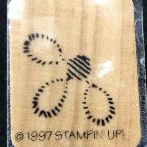 May include: A wooden stamp with a black and white design of three overlapping circles. The stamp is labeled "© 1997 STAMPIN' UP!"