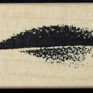 Puede incluir: Un sello de goma negro y blanco con un diseño de forma de labio estilizado.