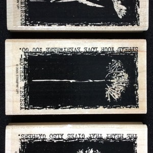 May include: Three wooden stamps with black rectangular designs and white floral illustrations. The top stamp reads "THE AMEN OF NATURE IS ALWAYS A FLOWER. - EMERSON." The middle stamp says "SPREAD YOUR LOVE EVERYWHERE YOU GO. - MOTHER TERESA." The bottom stamp reads "THE HEART THAT GIVES ALSO GATHERS."