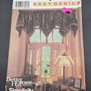May include: A Simplicity Easy Basics pattern envelope featuring a window treatment design. The cover showcases a window with a patterned valance, shutters, and a lamp. The Better Homes and Gardens logo is also visible.