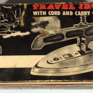 May include: Vintage travel iron in a black and white box with the text "TRAVEL IRON WITH CORD AND CARRY CASE". The iron is silver and has a black handle.