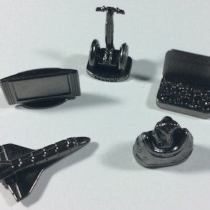 May include: Five silver-colored Monopoly game pieces: a television, a Segway, a laptop, a space shuttle, and a shoe.