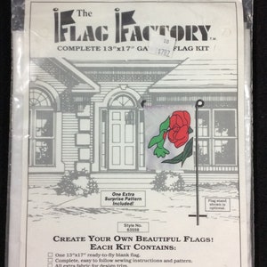 May include: A package containing a complete 13" x 17" flag kit with a hummingbird and red flower design. The kit includes a ready-to-fly blank flag, sewing instructions, and extra fabric for design trim. The kit is made in the USA with high-quality nylon fabric and is treated for protection against fading and deterioration. The package also includes the text "The Flag Factory" and "Create Your Own Beautiful Flags!"