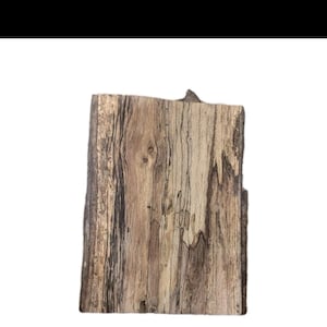 Puede incluir: Una pieza rectangular de madera con una superficie natural y texturizada. La veta de la madera presenta una mezcla de tonos marrones claros y oscuros, con algunas zonas que parecen casi negras. Los bordes son ásperos e irregulares, lo que le da un aspecto rústico.
