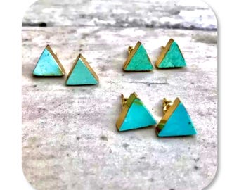 Könnte beinhalten: Ein Set mit vier dreieckigen Ohrringen mit goldfarbenem Rand und türkisfarbenen und hellblauen Steinen.