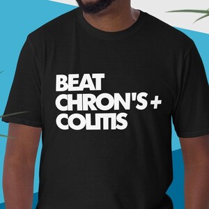 May include: A black t-shirt with white text that reads "BEAT CHRON'S + COLITIS".