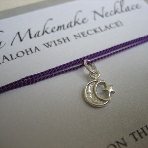 May include: A silver crescent moon charm with a star on a purple cord necklace. The card reads "Aloha Makemake Necklace (ALOHA WISH NECKLACE)"