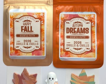 May include: Two resealable pouches, one gold and one orange, labeled Happy Fall and Autumn Dreams Scented Putty 2026 Drills & Chills. Below are two marbled leaf-shaped putty pieces and a small clear container topped with a white ghost figurine.