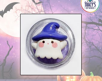 May include: A small white ghost figurine with pink cheeks and a dark blue witch hat, contained within a clear circular plastic container. The text LILYPADS - HAPPY GHOST appears at the top, and INCLUDES PURPLE, PINK & WHITE SPONGES at the bottom.