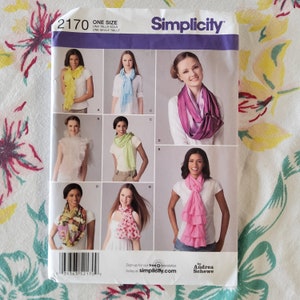 May include: Simplicity sewing pattern 2170 featuring various scarf designs. The pattern shows multiple scarf styles, including ruffled, fringed, and patterned options. The package includes the text "ONE SIZE" and the Simplicity logo.