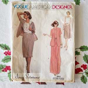 May include: Vintage Vogue American Designer sewing pattern #1842 by Jerry Silverman. The pattern features two different looks: a skirt and jacket set in beige and a skirt and jacket set in pink.