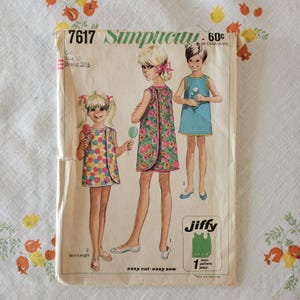 May include: A vintage Simplicity 7617 sewing pattern envelope for a girl's dress in size 10 with a 28.5 inch breast measurement. The cover features illustrations of three children wearing sleeveless dresses with floral and polka dot patterns.