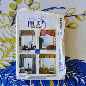 May include: A white McCall's Home Dec sewing pattern envelope, model M5286, featuring four window valance designs. The front displays photographs of box pleat, centre pleat, and scallop valances, with text indicating a 2-hour assembly time.