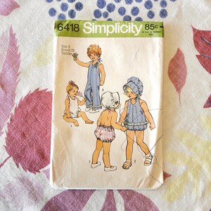 May include: Vintage Simplicity sewing pattern 6418 for toddler clothing. The pattern features illustrations of children in various outfits, including overalls, rompers, and a bonnet. The pattern's price is 85¢ in the USA and 95¢ in Canada.