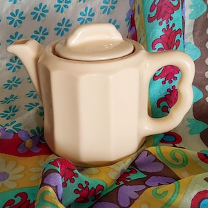 Tetera de una taza de piedra de hierro OPCO con ranuras para los dedos, mango de cerámica cilíndrica, exterior acanalado, color beige pálido, arena, vintage, años 30 y 40.